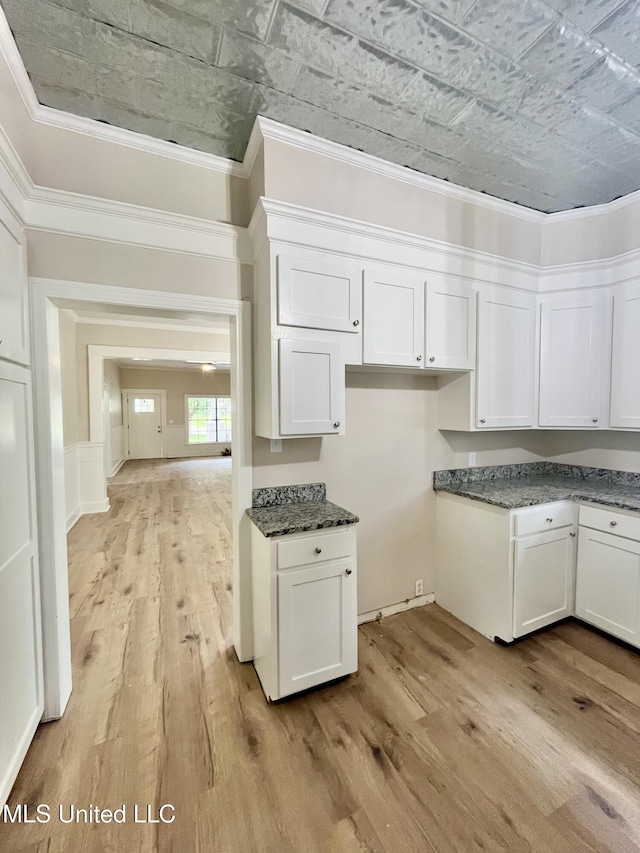 708 Lee Ave, Crystal Springs, MS 39059 - kitchen with light wood-type flooring, white cabinetry, an ornate ceiling, and ornamental molding