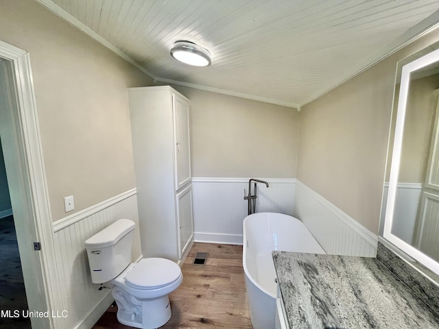 708 Lee Ave, Crystal Springs, MS 39059 - bathroom featuring a freestanding bath, wainscoting, and wood finished floors