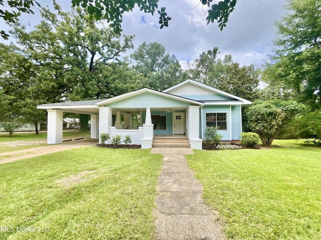 708 Lee Ave, Crystal Springs, MS 39059 - view of front of house featuring covered porch, an attached carport, and a front yard