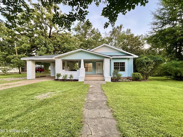 708 Lee Ave, Crystal Springs, MS 39059 - view of front of home with covered porch, a front lawn, a carport, and driveway
