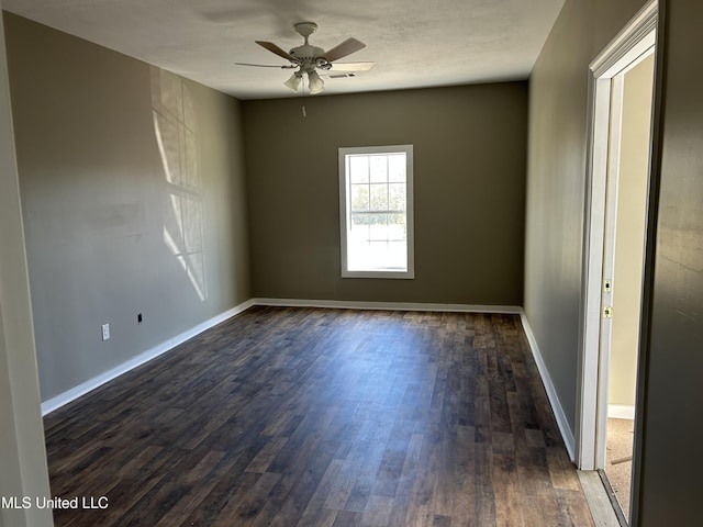 empty room with ceiling fan and dark wood-type flooring