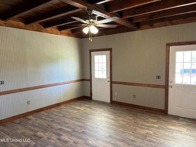 spare room featuring beam ceiling, ceiling fan, dark hardwood / wood-style flooring, and plenty of natural light