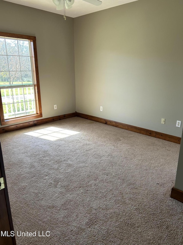 carpeted spare room featuring ceiling fan