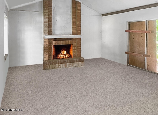 unfurnished living room featuring lofted ceiling, carpet floors, and a brick fireplace