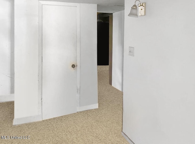 hallway featuring light colored carpet