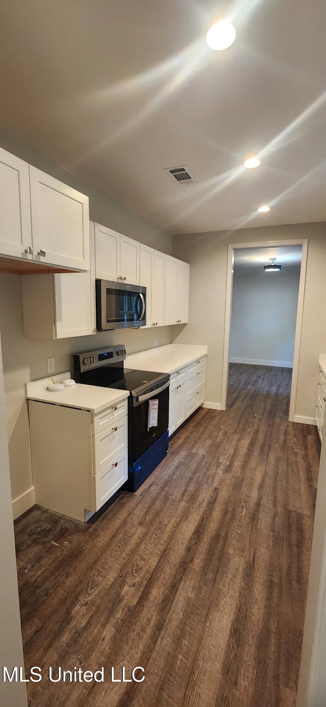 233 Allstate Dr, Jackson, MS 39211 - kitchen featuring range with electric stovetop, stainless steel microwave, dark wood-style flooring, and white cabinets