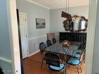 dining area featuring ornamental molding and dark hardwood / wood-style flooring