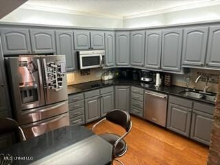 kitchen featuring sink, light hardwood / wood-style floors, stainless steel appliances, gray cabinets, and crown molding