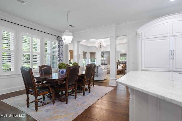 dining room with crown molding, a notable chandelier, decorative columns, and dark wood-type flooring
