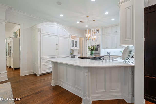 kitchen with a sink, white cabinetry, a peninsula, and glass insert cabinets