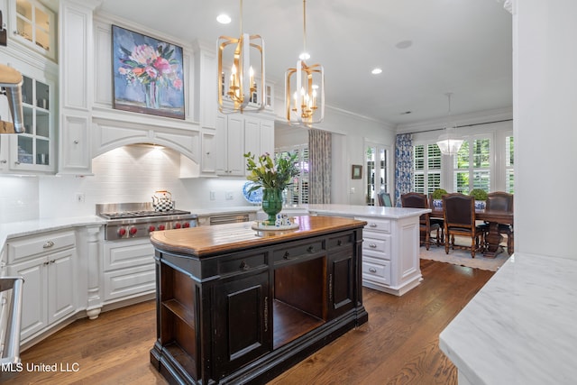 kitchen featuring stainless steel gas cooktop, white cabinetry, an inviting chandelier, and a center island