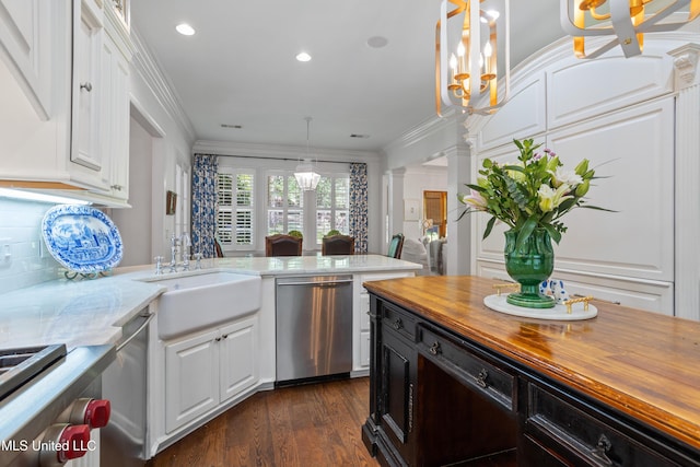 kitchen featuring white cabinets, a sink, dishwasher, wood counters, and decorative columns
