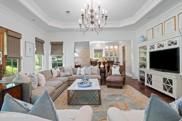 living area with an inviting chandelier, ornamental molding, and a wealth of natural light