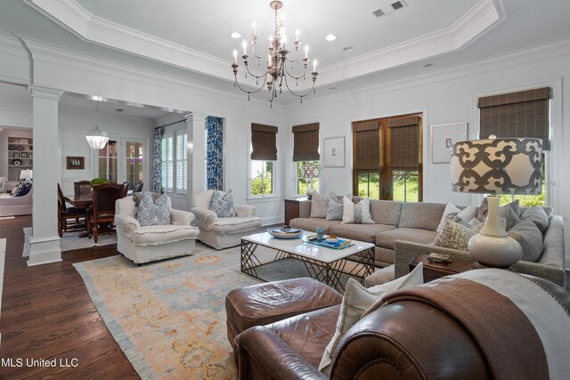living room with visible vents, ornamental molding, decorative columns, dark wood-style floors, and a notable chandelier