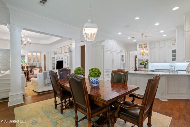dining area with decorative columns, dark wood-style floors, a chandelier, and visible vents
