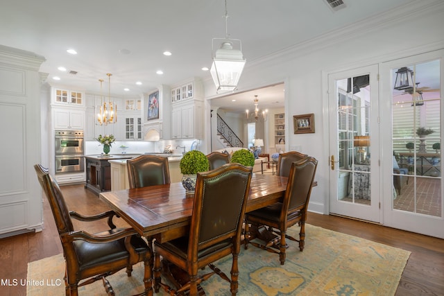 dining room featuring crown molding, recessed lighting, wood finished floors, and a chandelier