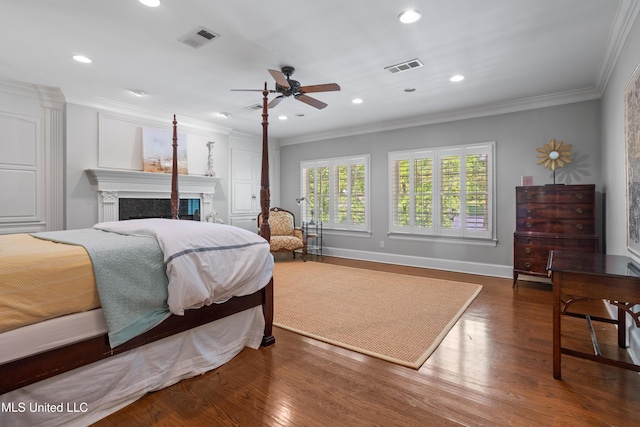bedroom featuring visible vents, wood finished floors, a fireplace, baseboards, and recessed lighting