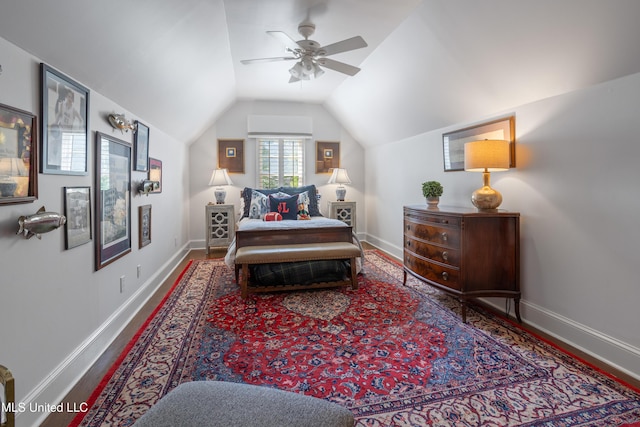 living area featuring a ceiling fan, baseboards, vaulted ceiling, and wood finished floors