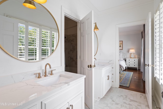 ensuite bathroom featuring a sink, ornamental molding, ensuite bath, and two vanities