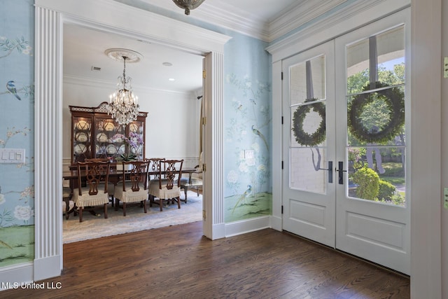 entryway featuring crown molding, french doors, dark wood-style floors, and a notable chandelier