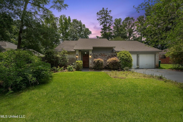 6944 Apona St, Diamondhead, MS 39525 - view of front of home with brick siding, an attached garage, concrete driveway, and a front yard