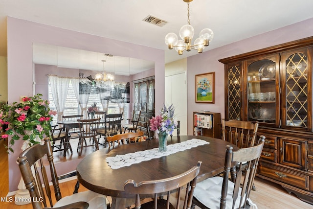 6944 Apona St, Diamondhead, MS 39525 - dining area featuring a chandelier and light wood-style flooring