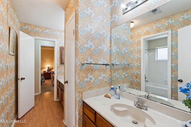 6944 Apona St, Diamondhead, MS 39525 - ensuite bathroom featuring vanity, wood finished floors, washtub / shower combination, and baseboards