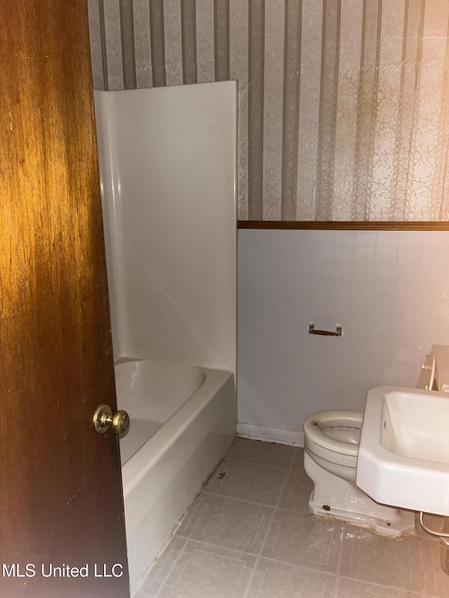 full bathroom featuring tile patterned floors, toilet, shower / washtub combination, and sink