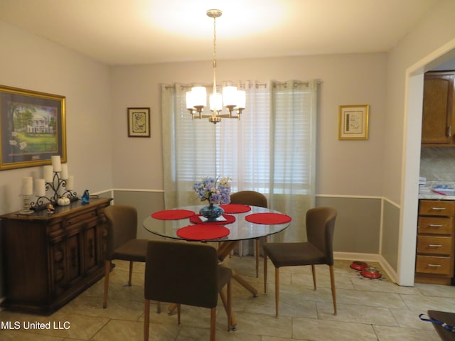 dining space featuring light tile patterned floors, baseboards, and a chandelier