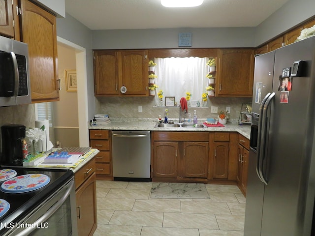 kitchen featuring brown cabinets, appliances with stainless steel finishes, open shelves, and a sink