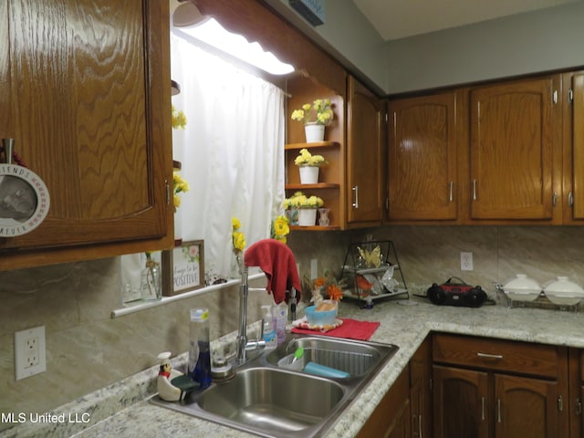 kitchen with a sink, open shelves, tasteful backsplash, and light countertops