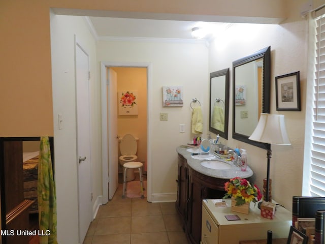 bathroom with tile patterned floors, vanity, baseboards, and ornamental molding