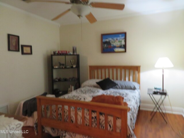 bedroom featuring a ceiling fan, wood finished floors, and baseboards