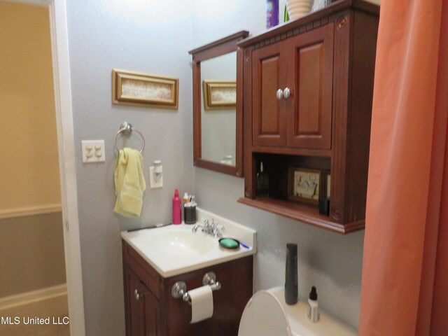 half bath featuring toilet and vanity