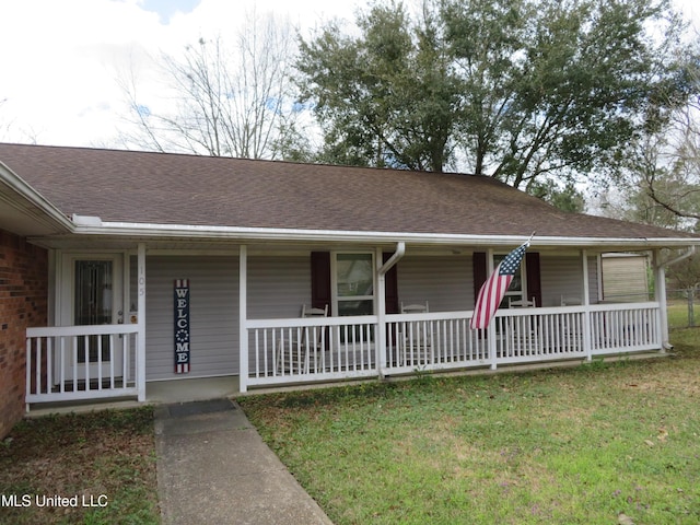 single story home with a porch, a front yard, and roof with shingles