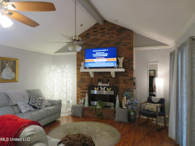 living area with a brick fireplace, vaulted ceiling with beams, wood finished floors, and ceiling fan