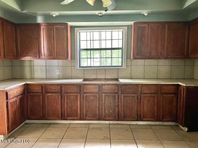 3916 Oakhill Dr, Jackson, MS 39206 - kitchen featuring light countertops, light tile patterned floors, decorative backsplash, and a ceiling fan