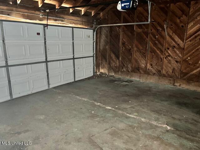 3916 Oakhill Dr, Jackson, MS 39206 - garage featuring a garage door opener and wooden walls