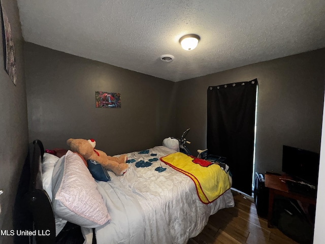 710 Benning Rd, Jackson, MS 39206 - bedroom with wood finished floors, a textured ceiling, and baseboards
