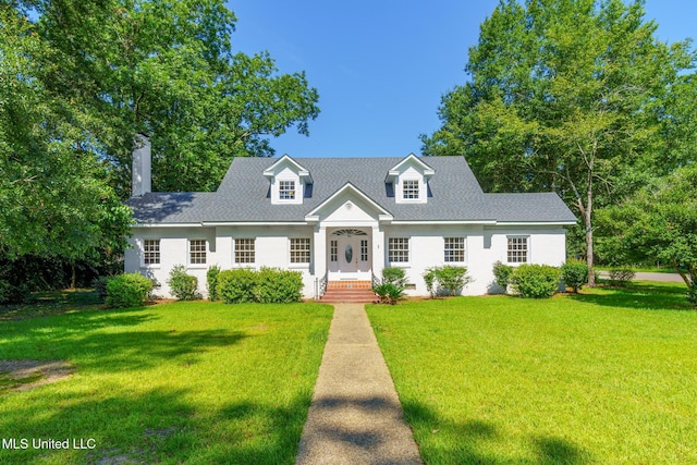 cape cod house featuring roof with shingles and a front yard