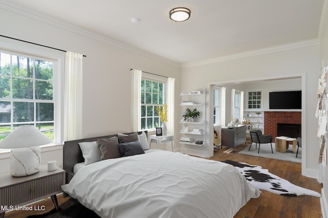 bedroom featuring crown molding, a fireplace, and wood finished floors