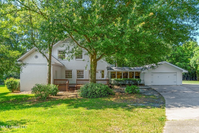 view of front of home with a garage, concrete driveway, and a front lawn