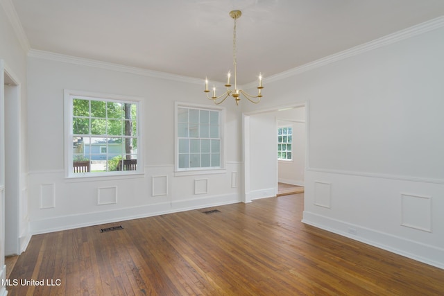 unfurnished room with a wainscoted wall, wood-type flooring, visible vents, ornamental molding, and a chandelier