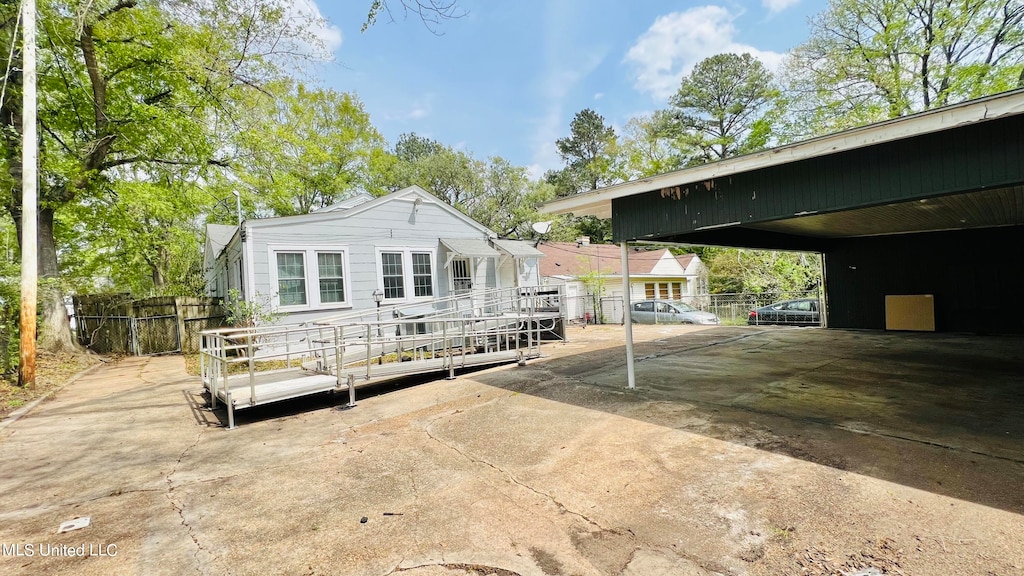 rear view of property with a wooden deck and a carport