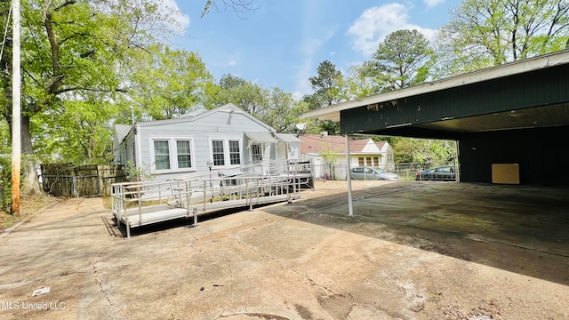 rear view of property with a wooden deck and a carport