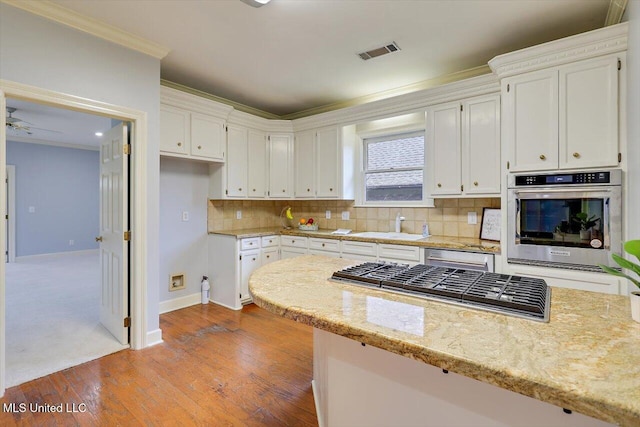 kitchen with visible vents, appliances with stainless steel finishes, white cabinets, and light stone counters