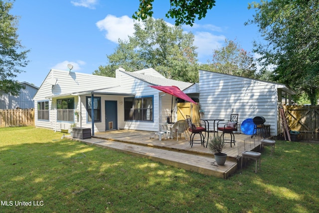 back of property featuring a deck and a yard