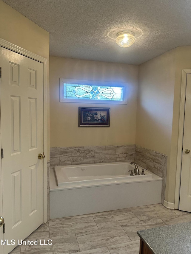 5875 White Ridge Cir W, Olive Branch, MS 38654 - bathroom featuring plenty of natural light, a garden tub, and a textured ceiling