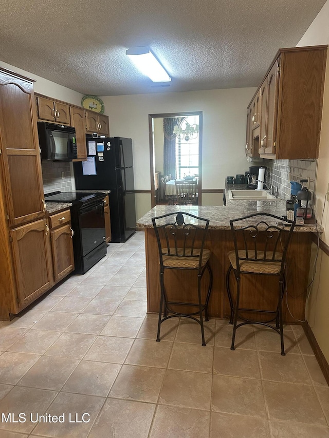 5875 White Ridge Cir W, Olive Branch, MS 38654 - kitchen featuring black appliances, a peninsula, a sink, a textured ceiling, and decorative backsplash