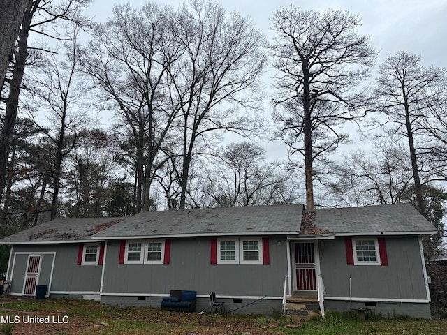 view of front of home with crawl space, a chimney, and entry steps